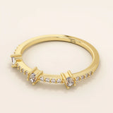 Side angle view of a 14k solid yellow gold band with three baguette cut moissanite stones and pavé set round moissanite accents, minimal and refined bridal jewelry

