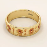 Side angle view of a 14k solid yellow gold engraved wedding band with repeating floral and fan motifs
