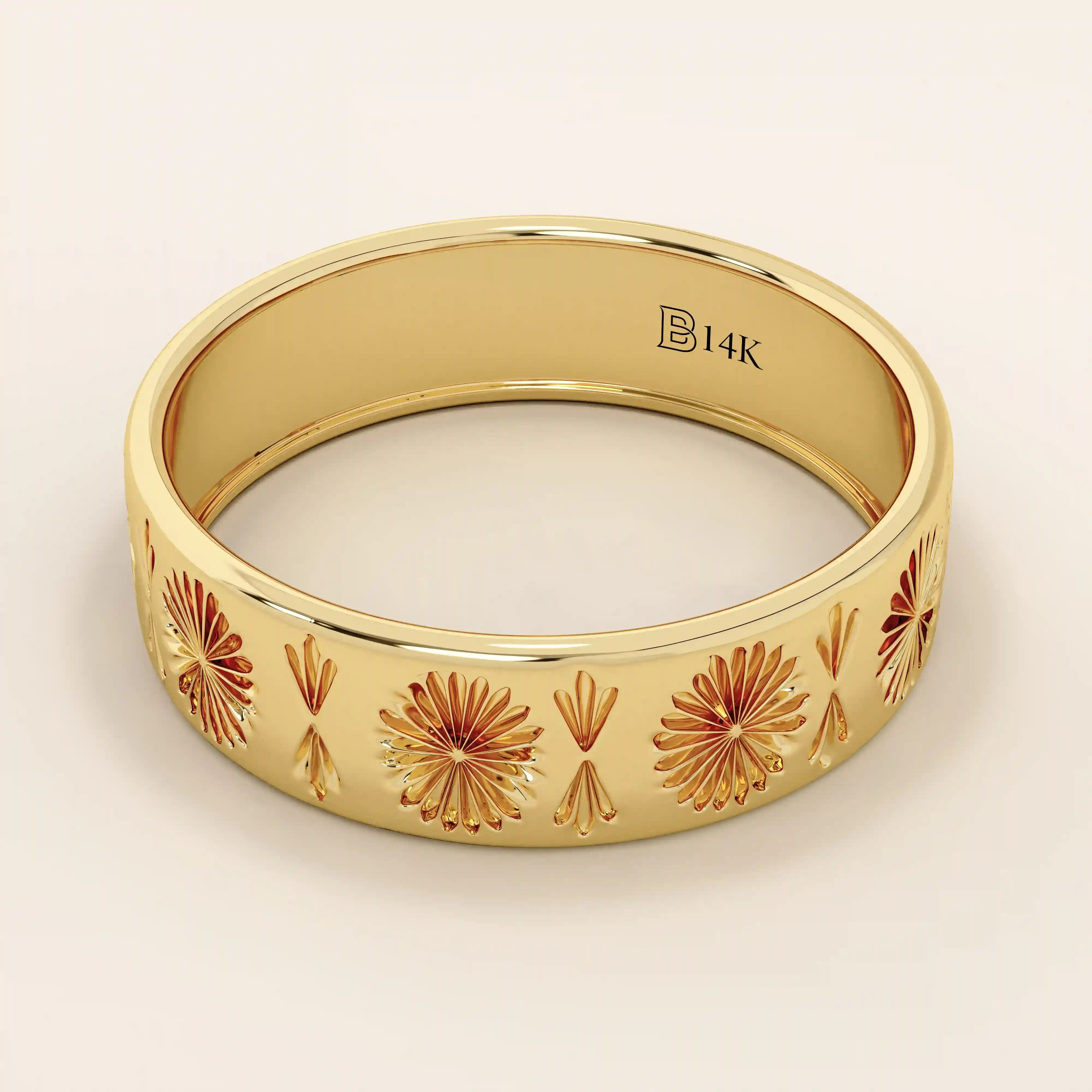Side angle view of a 14k solid yellow gold engraved wedding band with repeating floral and fan motifs
