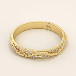 Side angle view of a 14k solid yellow gold twisted eternity wedding band with moissanites set in an interwoven design
