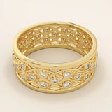 Side angle view of a 14k solid yellow gold wedding band with a detailed open lattice design and bezel-set moissanite stones
