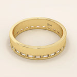 Side angle view of a 14k solid yellow gold wedding band with baguette-cut moissanite stones in a continuous channel setting
