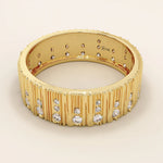 Side angle view of a 14k solid yellow gold wide wedding band with wood grain texture and pavé set round brilliant cut moissanite stones, stylish and unique bridal jewelry

