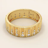 Side angle view of a 14k solid yellow gold wide wedding band with wood grain texture and pavé set round brilliant cut moissanite stones, stylish and unique bridal jewelry

