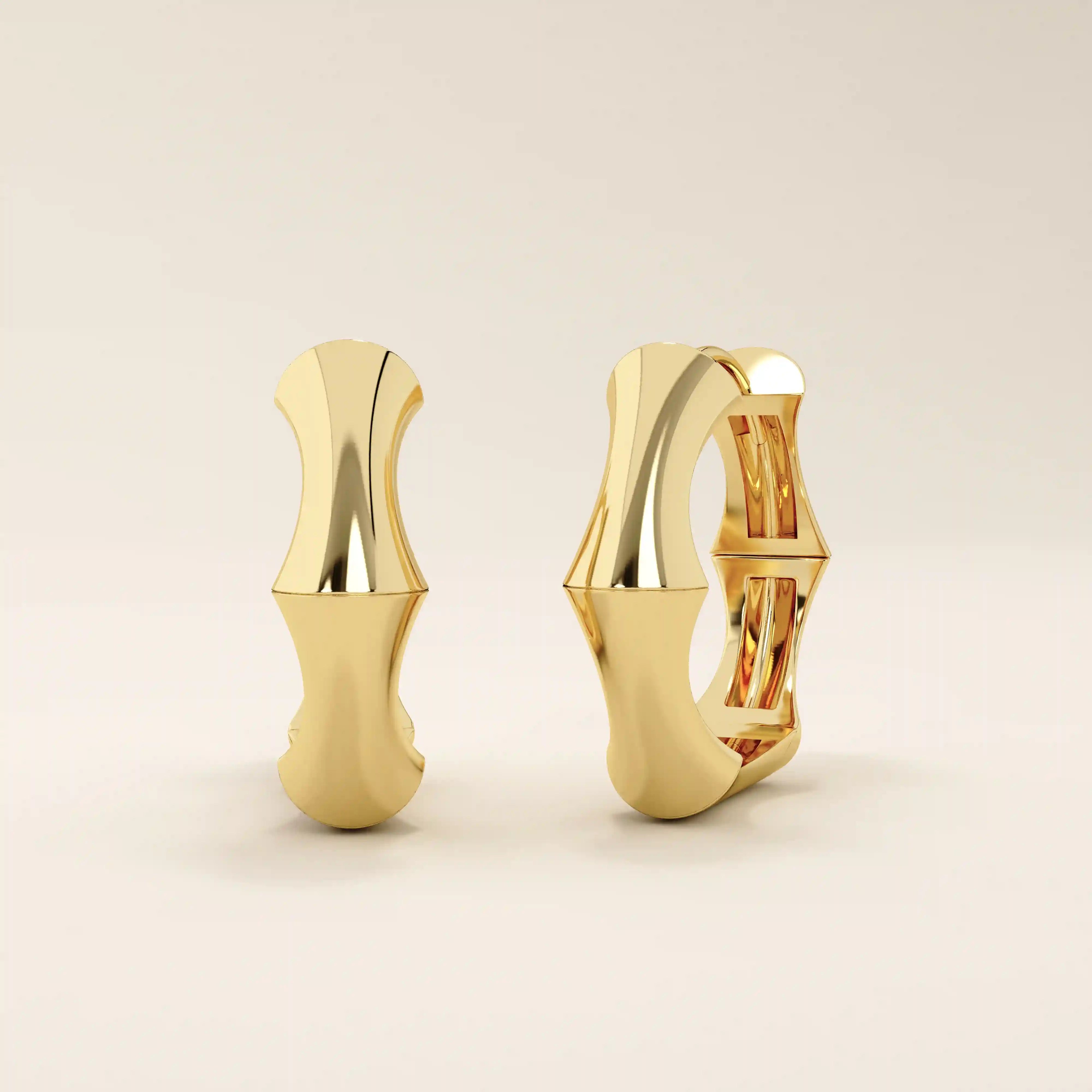 Side profile view of 14k solid yellow gold bone hoop earrings, showcasing their contoured silhouette and smooth high-polish shine.
