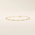 Side view of a 14k solid yellow gold bar chain bracelet, showing the slender rectangular links and highly polished finish that catches the light beautifully.
