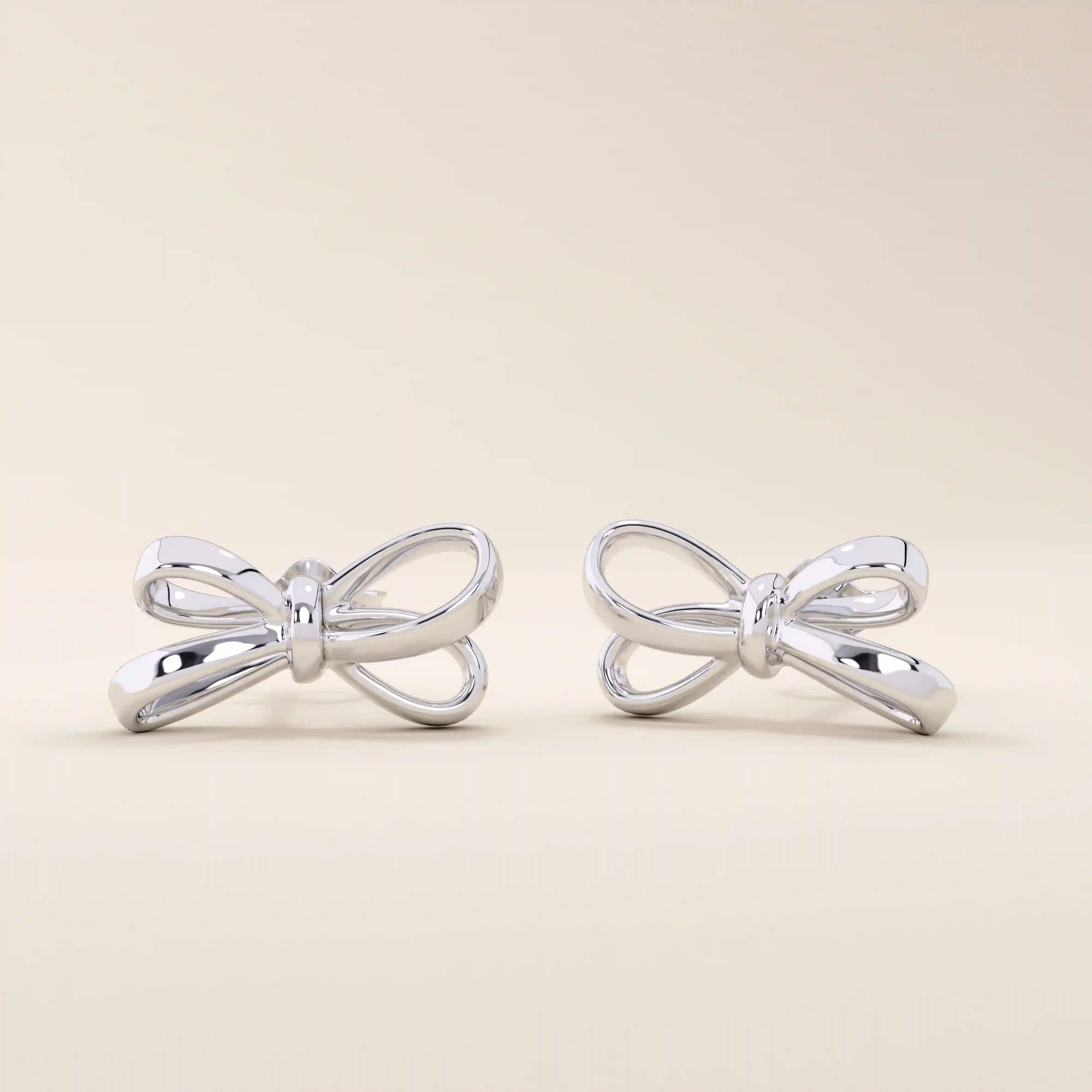 Simple ribbon stud earrings in 14k white gold, crafted in a delicate bow shape.
