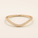 Slim curved stacking ring in 14k solid gold with a delicate twisted band. Designed to nest with engagement rings or wear alone for subtle texture.