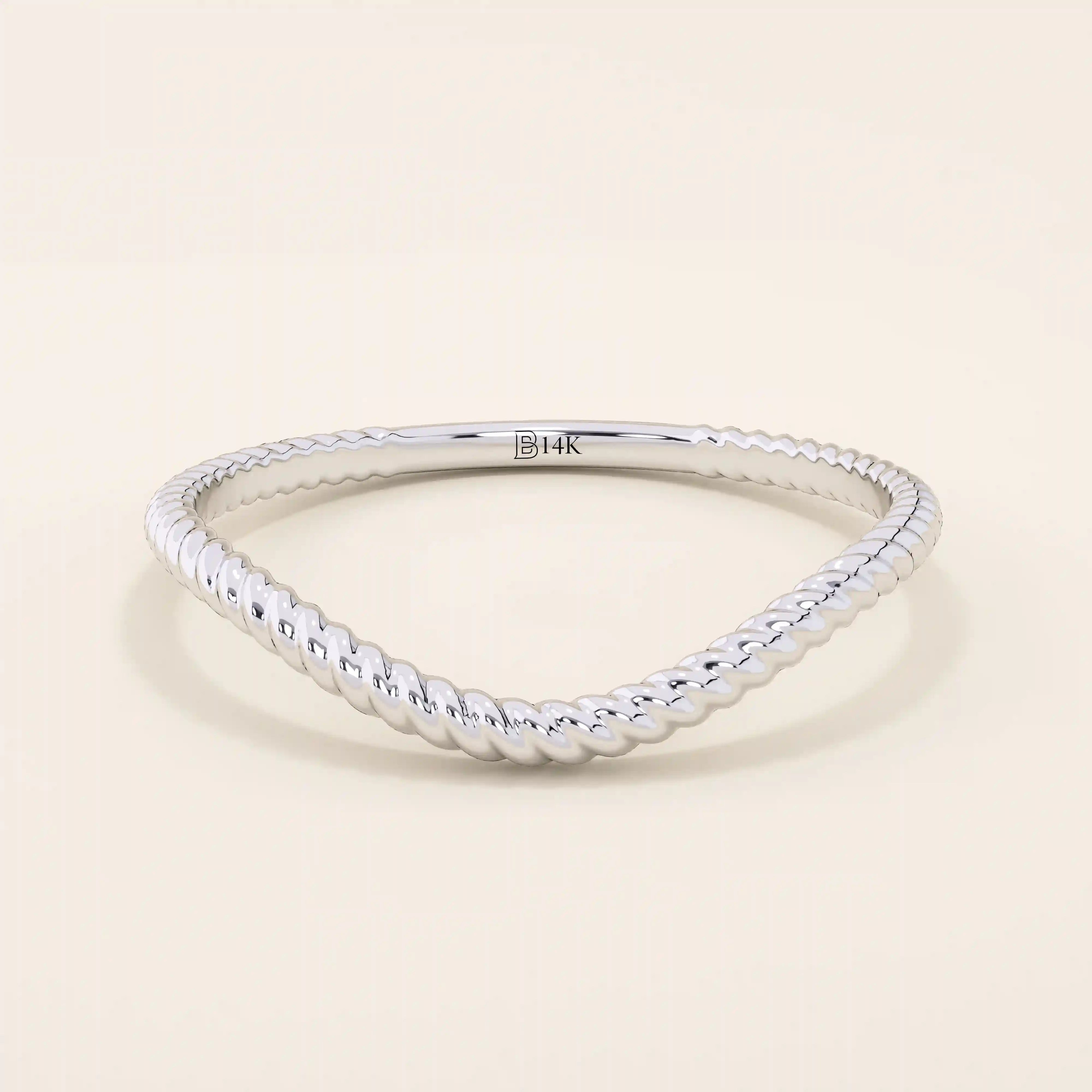 Slim curved stacking ring in 14k solid gold with a delicate twisted band. Designed to nest with engagement rings or wear alone for subtle texture.