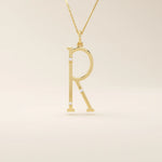 Slim initial letter necklace in 14k solid gold, accented with tiny moissanites for subtle sparkle. A sleek and personal everyday accessory.