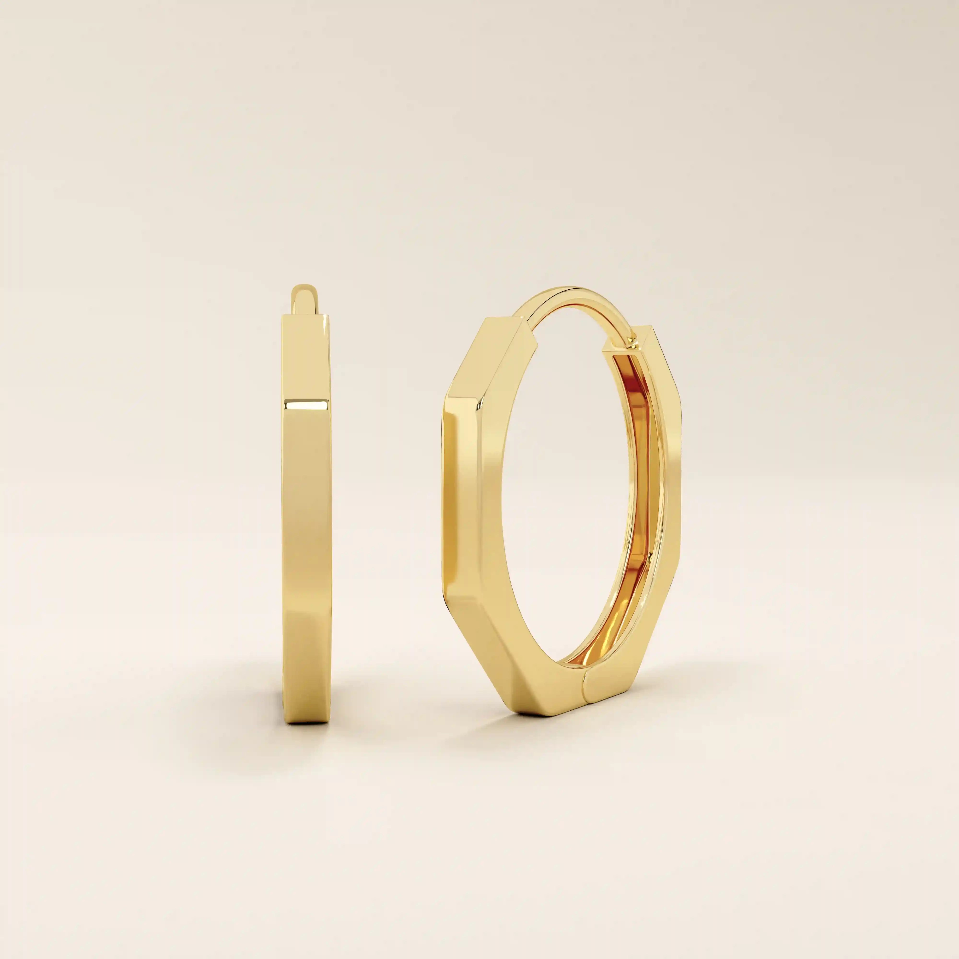 Small minimal hoop earrings in 14k yellow gold with a sleek geometric design.
