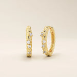 Twist rope hoop earrings in 14k yellow gold, accented with sparkling moissanite stones.
