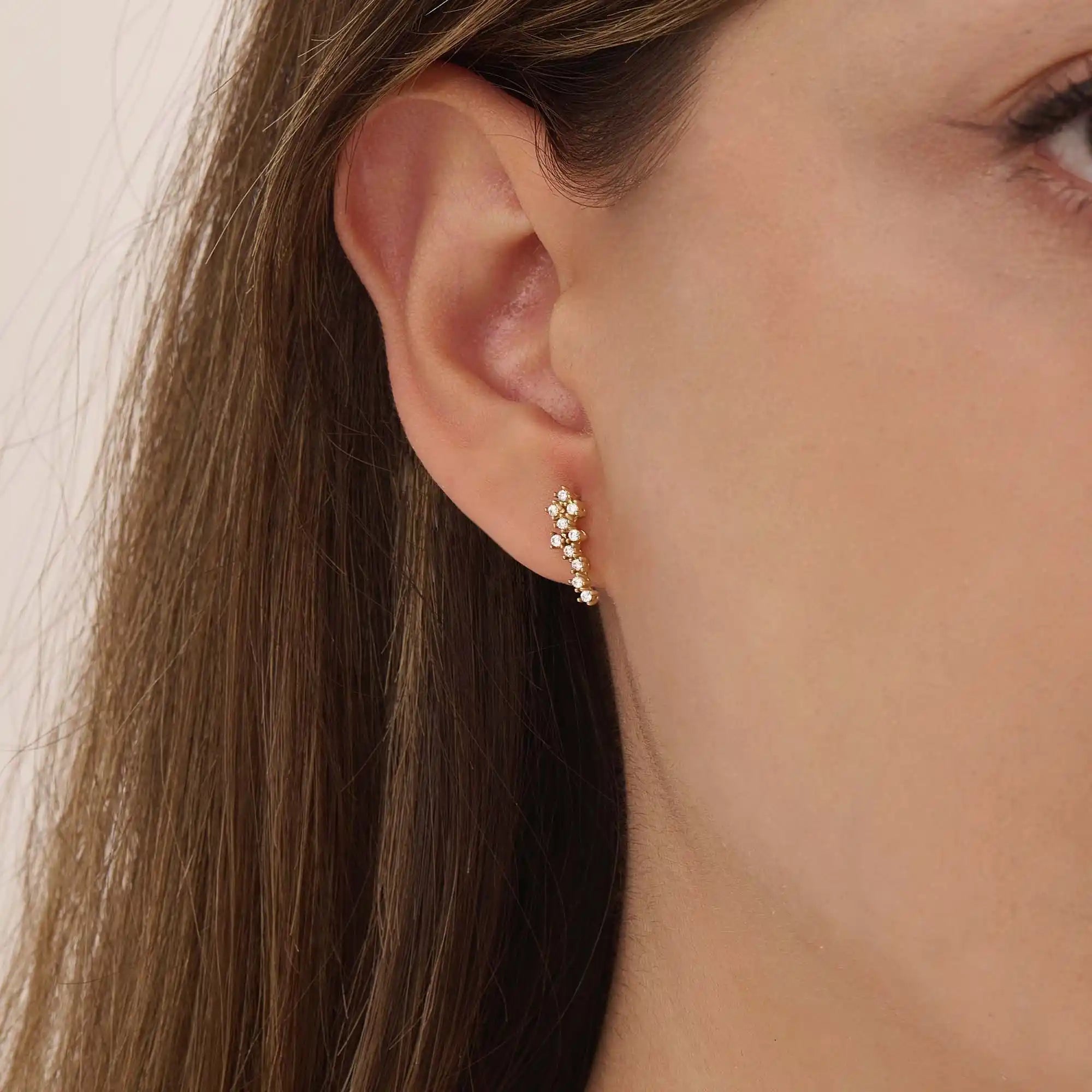 Woman wearing 14k solid gold cluster stud earrings with moissanite accents. A subtle yet eye-catching style for daily looks. Perfect for stacking or solo wear.