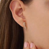 Woman wearing 14k solid gold cluster stud earrings with moissanite accents. A subtle yet eye-catching style for daily looks. Perfect for stacking or solo wear.
