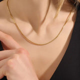 Woman wearing a 14k solid gold box chain necklace with sleek, structured links. Minimalist and versatile gold chain for everyday styling. Perfect on its own or with other pieces. 