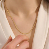 Woman wearing a 14k solid gold curb chain necklace with smooth, flat links that catch the light. A bold yet classic piece for daily styling. Perfect worn solo or stacked.
