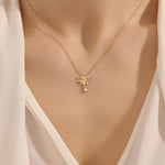 Woman wearing a 14k solid gold flower necklace with five petals and a sparkling dangling moissanite. Nature-inspired and graceful gold jewelry. Perfect for soft, romantic styling.
