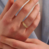 Woman wearing a 14k solid gold flower wedding band with raised floral details. A soft and timeless design for everyday use. Ideal as a meaningful or alternative wedding ring.