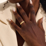 Woman wearing a 14k solid gold flower wedding band with raised floral details. A soft and timeless design for everyday use. Ideal as a meaningful or alternative wedding ring.