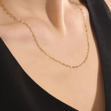 Woman wearing a 14k solid gold lip chain necklace with smooth, rounded links. A bold yet minimal piece for daily style. Perfect as a statement chain or base layer.