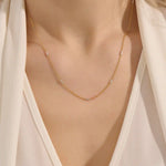 Woman wearing a 14k solid gold mixed metal bar chain necklace with polished yellow and white gold segments. A unique, eye-catching design for daily looks. Great for bold layering or worn alone.