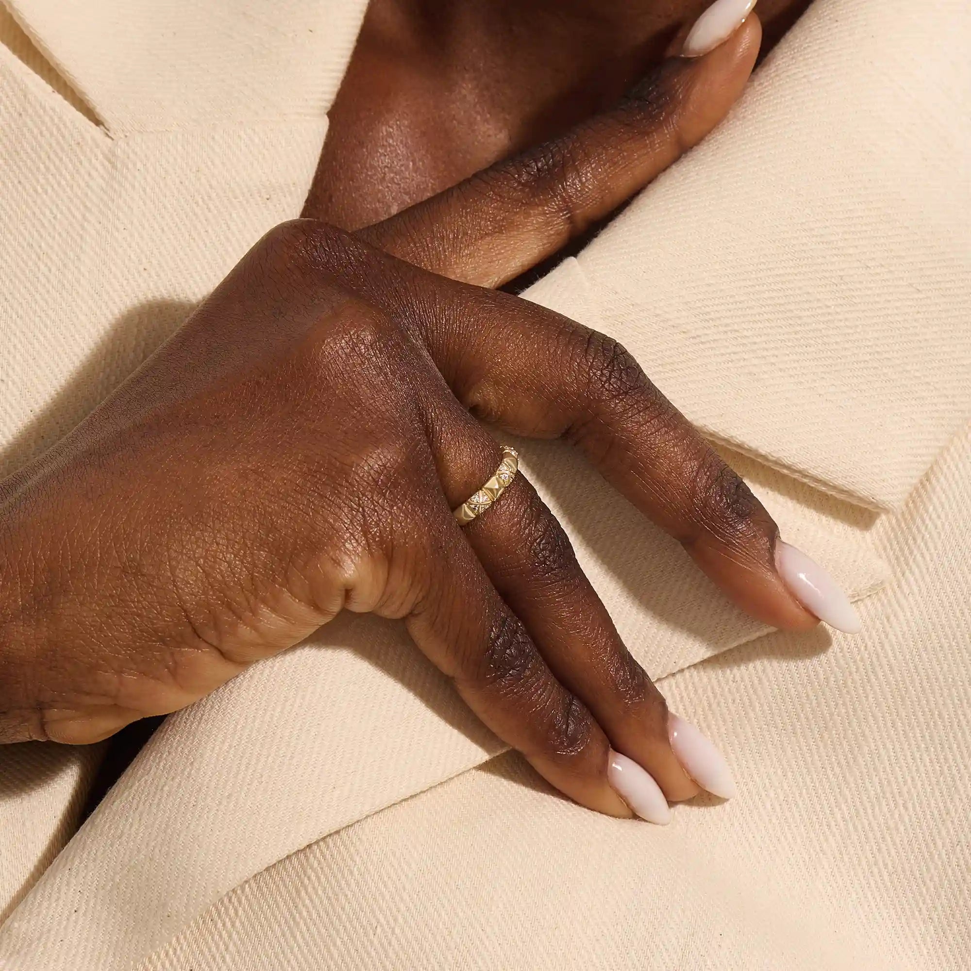 Woman wearing a 14k solid gold pyramid-style band with shimmering pave moissanites. A unique and structured gold ring. Ideal for weddings or everyday elegance.