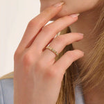 Woman wearing a 14k solid gold pyramid-style band with shimmering pave moissanites. A unique and structured gold ring. Ideal for weddings or everyday elegance.