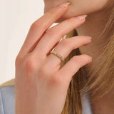 Woman wearing a 14k solid gold pyramid-style band with shimmering pave moissanites. A unique and structured gold ring. Ideal for weddings or everyday elegance.