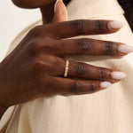 Woman wearing a 14k solid gold pyramid-style band with shimmering pave moissanites. A unique and structured gold ring. Ideal for weddings or everyday elegance.