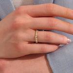 Woman wearing a 14k solid gold pyramid-style band with shimmering pave moissanites. A unique and structured gold ring. Ideal for weddings or everyday elegance.