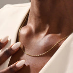 Woman wearing a 14k solid gold rectangle link chain necklace. Sleek and modern gold chain that adds a statement to any outfit. Easy to layer or wear solo.