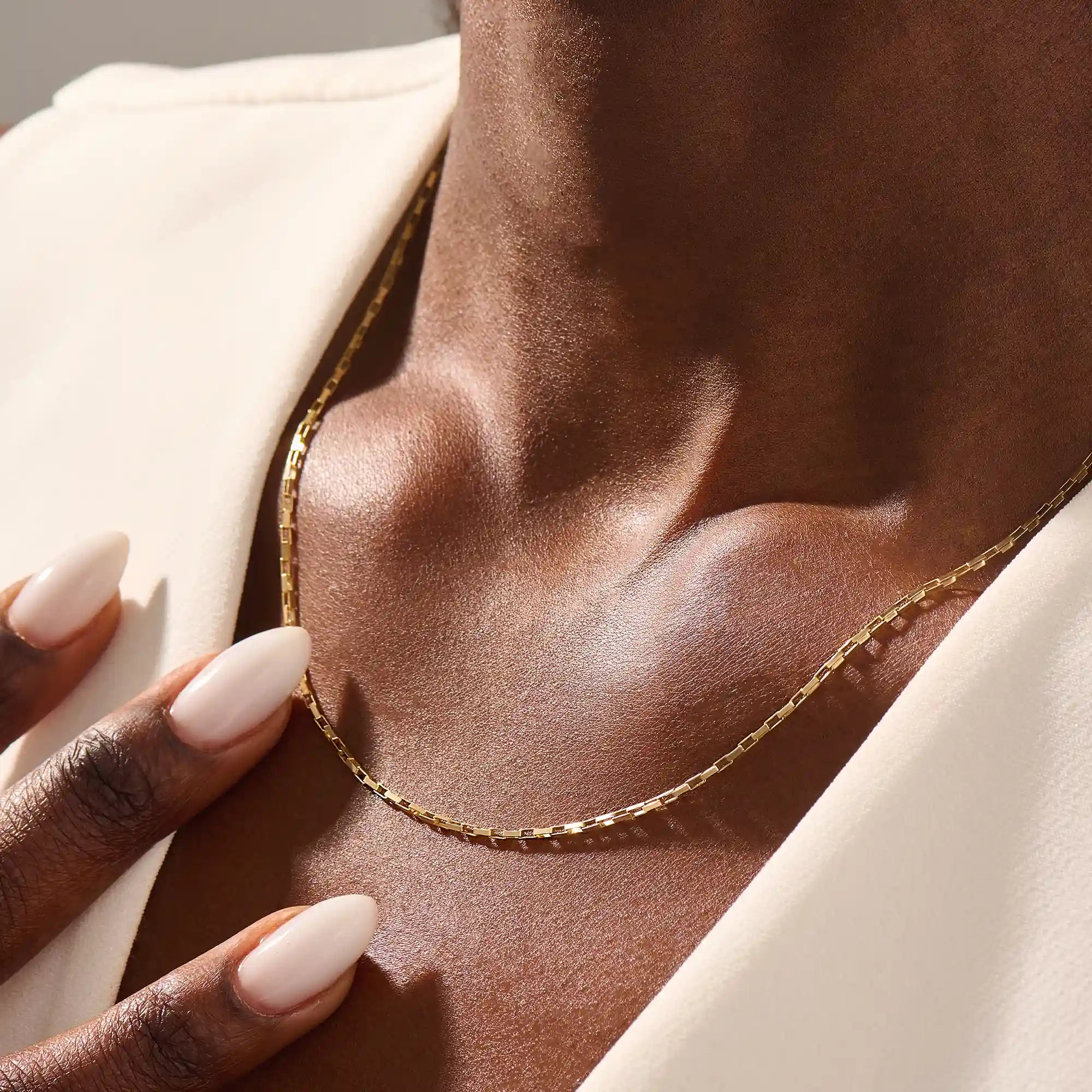 Woman wearing a 14k solid gold rectangle link chain necklace. Sleek and modern gold chain that adds a statement to any outfit. Easy to layer or wear solo.