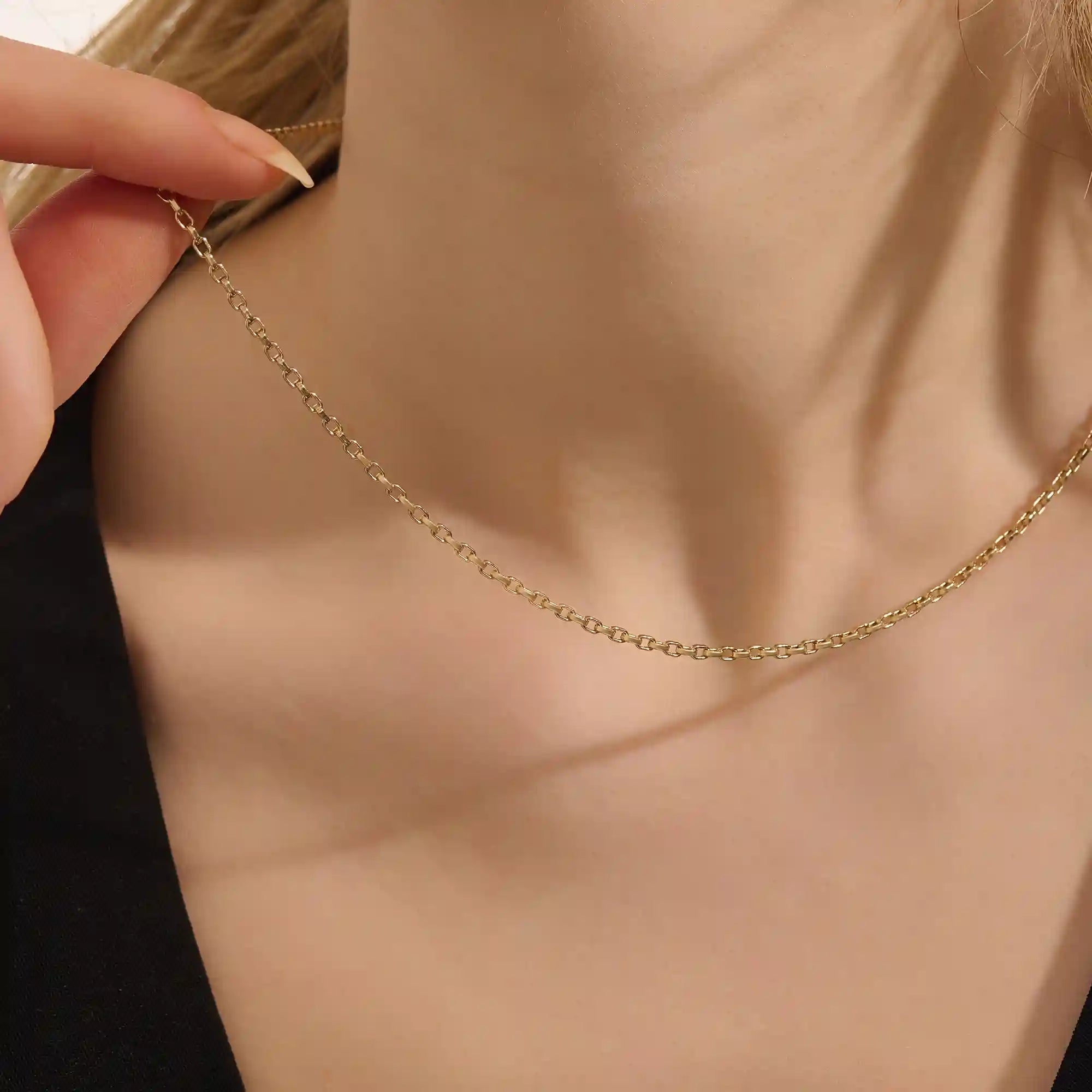 Woman wearing a 14k solid gold rolo chain necklace with smooth round links. A simple yet bold chain for daily outfits. Ideal for layering or wearing solo.