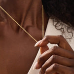 Woman wearing a 14k solid gold rolo chain necklace with smooth round links. A simple yet bold chain for daily outfits. Ideal for layering or wearing solo.