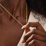 Woman wearing a 14k solid gold rolo chain necklace with smooth round links. A simple yet bold chain for daily outfits. Ideal for layering or wearing solo.
