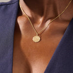 Woman wearing a 14k solid gold rose pendant necklace with delicate moissanite details. Floral-inspired minimalist jewelry styled for everyday. A timeless gold necklace for women.