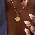 Woman wearing a 14k solid gold round necklace with a Sakura flower motif. Elegant floral-inspired jewelry for women. Perfect for everyday gold layering.