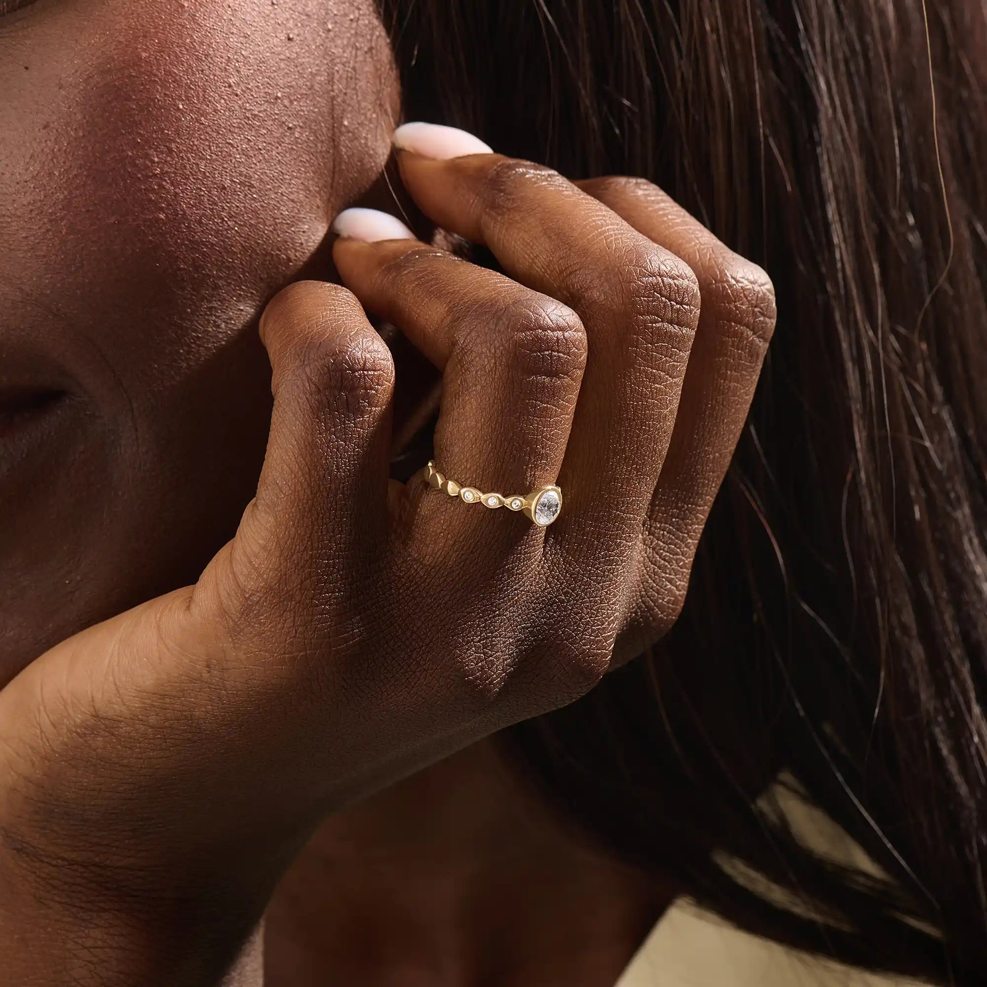 Woman wearing a 14k solid gold solitaire engagement ring with a bezel-set moissanite and fine band details. Elegant and minimal with a unique touch. Ideal for everyday wear and special moments.