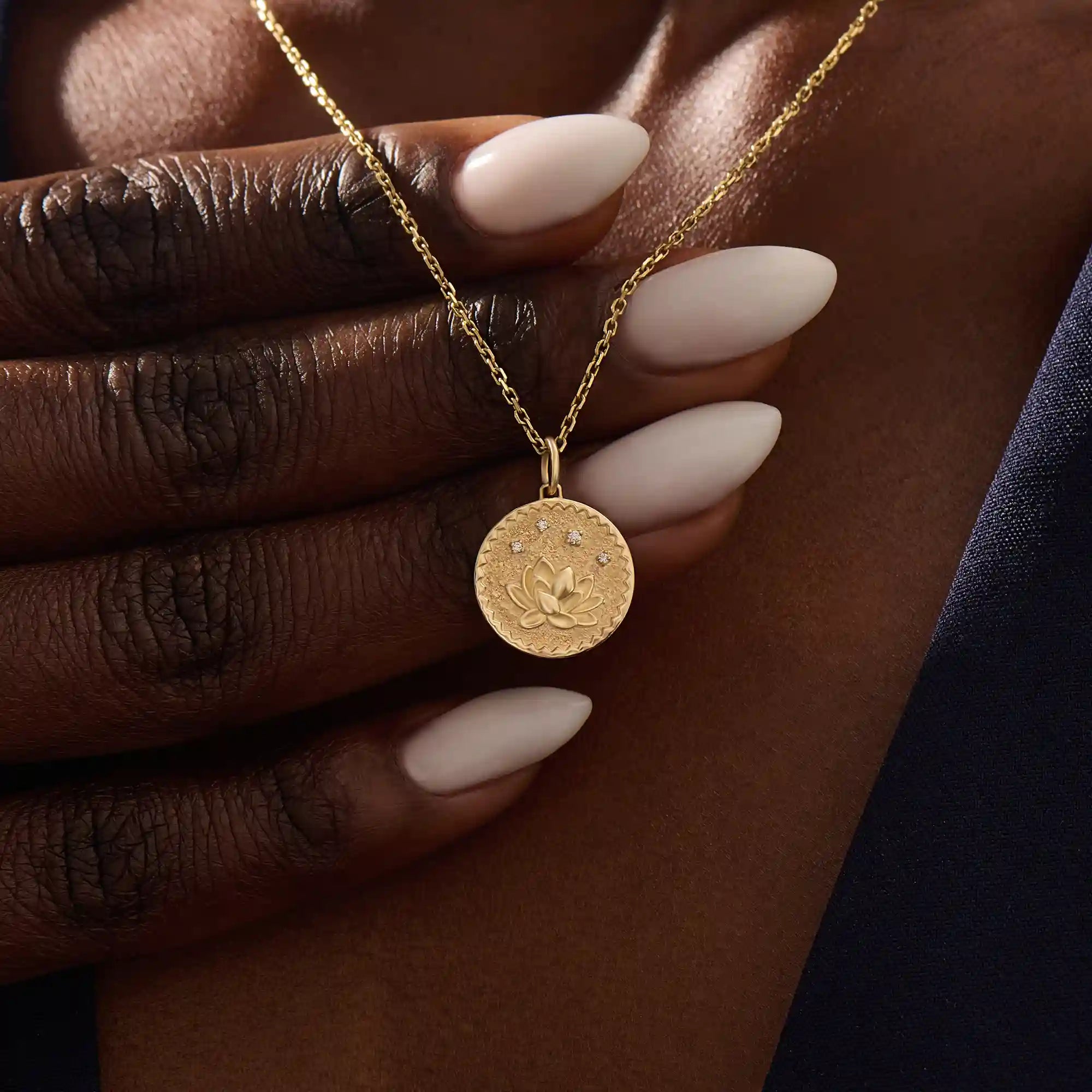 Woman wearing a 14k solid gold water lily pendant necklace with a delicate moissanite accent. Nature-inspired fine jewelry styled for everyday wear. Elegant and minimalist gold necklace for women.