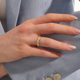 Close-up of a woman's hand wearing a 14k solid yellow gold ivy leaf wedding band. The detailed leaf motifs and smooth polished interior reflect a blend of natural inspiration and artisan craftsmanship, making it a distinctive and elegant choice for daily wear or special occasions.
