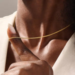 Woman wearing a 14k solid gold wheat chain necklace with a fine braided design. Subtle shine and elegant look for everyday outfits. Great as a standalone or layered piece.