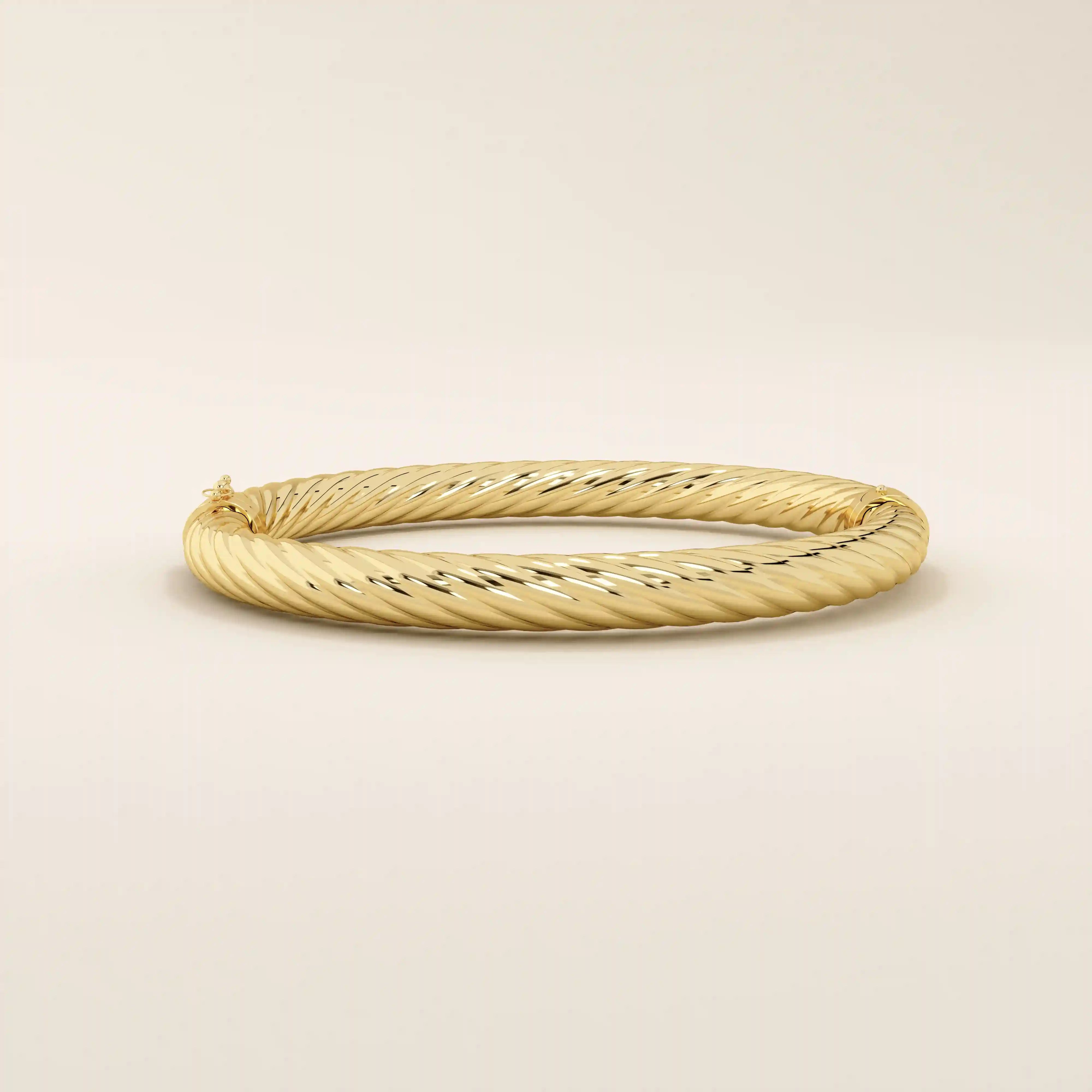 Angled view of a 14k yellow gold rope bangle highlighting its textured rope twists and elegant rounded silhouette.
