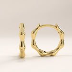 14k gold vermeil bone hoop earrings featuring an organic sculptural design inspired by natural bone shapes, blending modern artistry with timeless shine.

