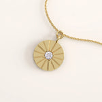 14k gold vermeil coin necklace featuring a round medallion pendant with a radiant engraved design and a central cubic zirconia for timeless sophistication.
