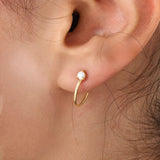 Model wearing 14k gold vermeil solo hoop earrings showcasing a single sparkling cubic zirconia, perfect for an understated yet sophisticated everyday look.
