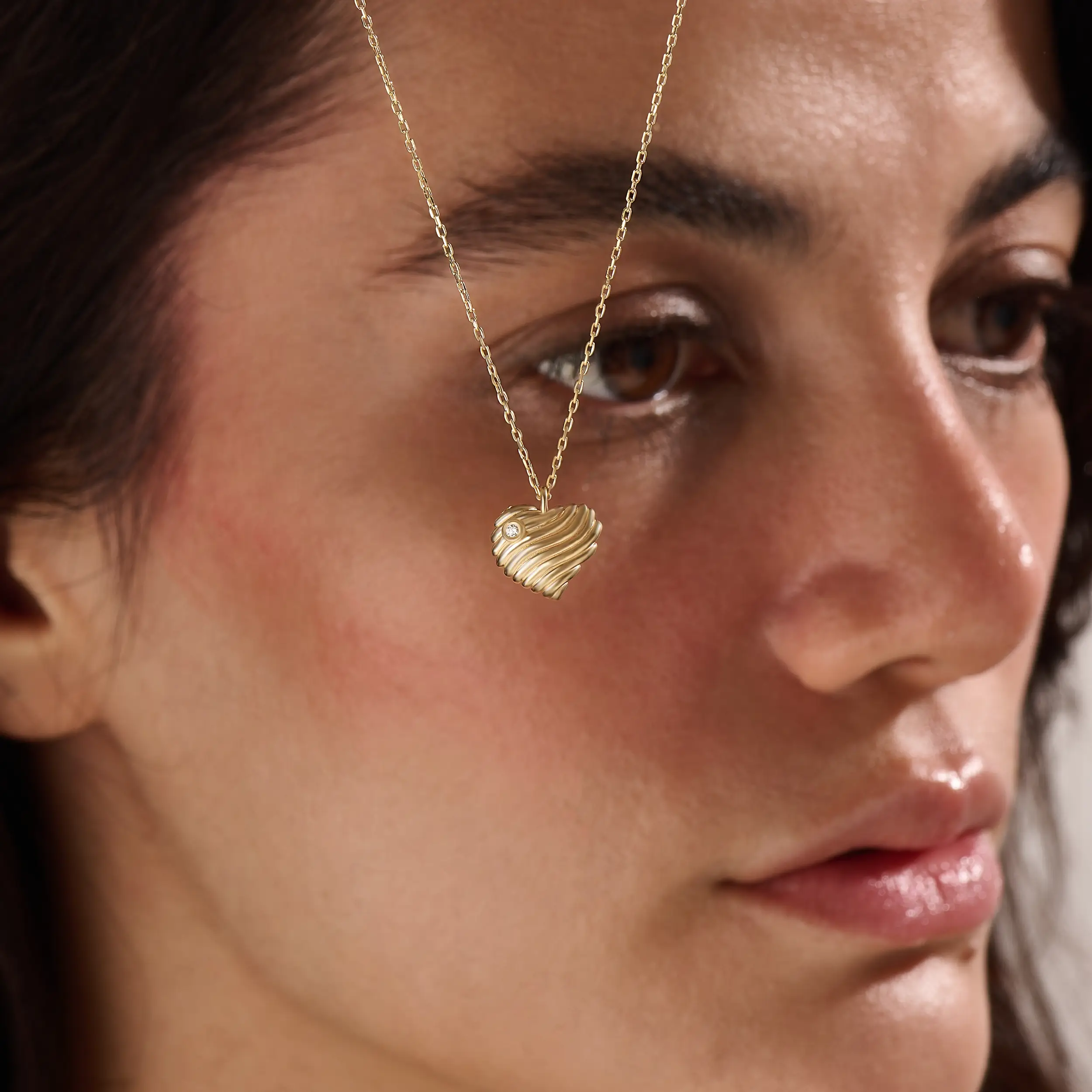 Model wearing a 14k gold vermeil 3D heart necklace featuring a sculpted heart pendant with soft curves and a delicate cubic zirconia accent for a graceful, contemporary look.
