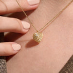 Model wearing a 14k gold vermeil 3D heart necklace featuring a sculpted heart pendant with soft curves and a delicate cubic zirconia accent for a graceful, contemporary look.
