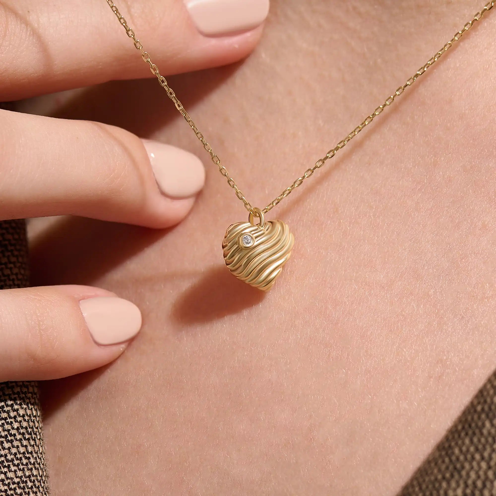 Model wearing a 14k gold vermeil 3D heart necklace featuring a sculpted heart pendant with soft curves and a delicate cubic zirconia accent for a graceful, contemporary look.

