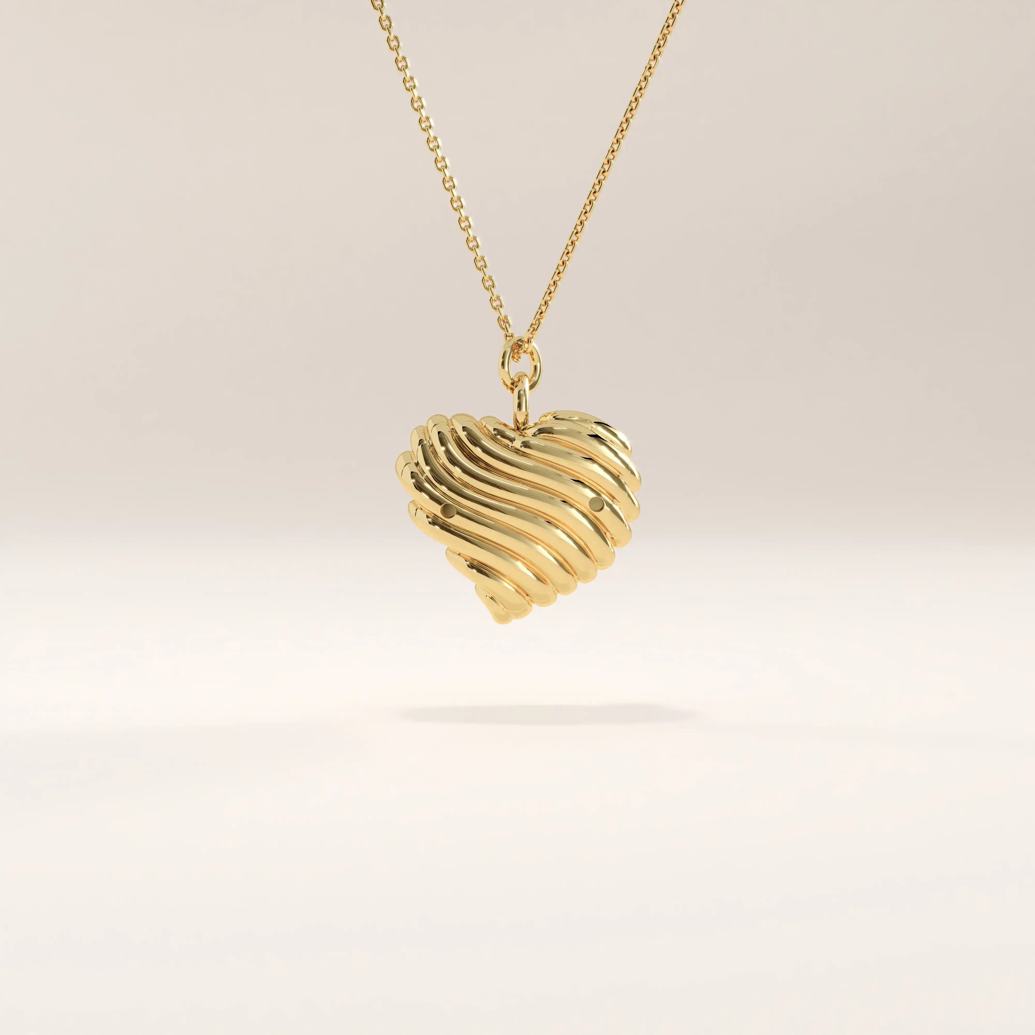 Side view of 14k gold vermeil 3D heart necklace highlighting its layered, fluid heart silhouette and bezel-set gemstone detail.

