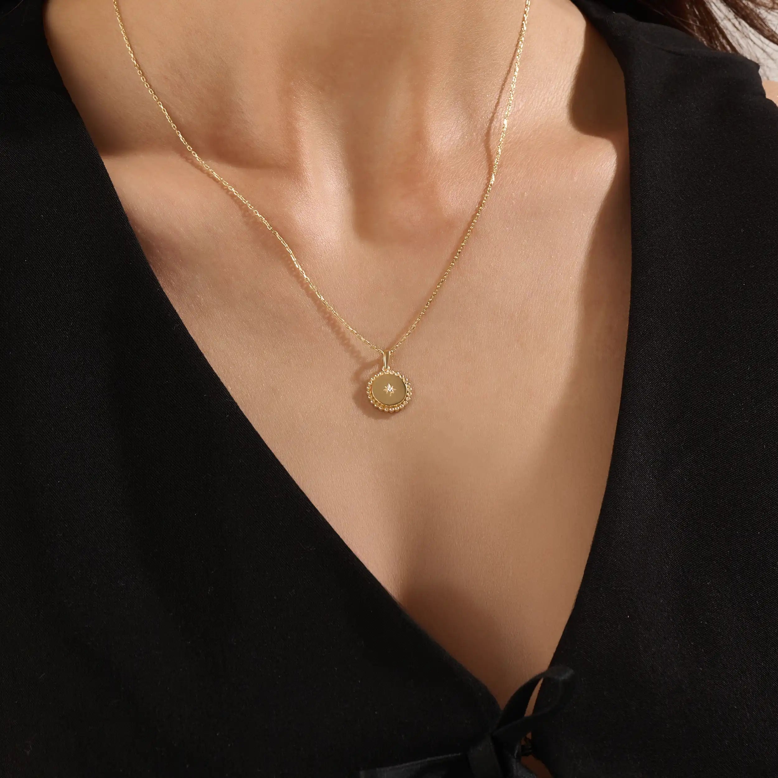 Model wearing a 14k gold vermeil beaded coin necklace featuring a gleaming pendant with a star-set cubic zirconia and ornate beaded border for a touch of everyday luxury.
